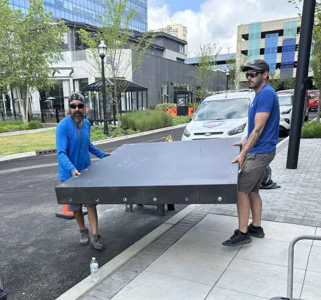 FRA team members carrying a flood panel to an installation site